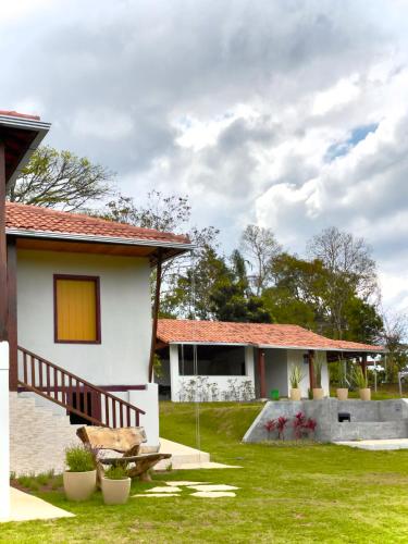 a house with a grass yard next to a building at Sitio Recanto Maçussa in Ouro Preto