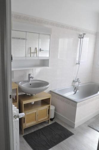 une salle de bain avec une baignoire et un lavabo et une baignoire dans l'établissement Ô Rivage, maison familiale bord de Loire, à Montjean-sur-Loire