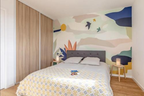 a bedroom with a bed with a painting on the wall at Le May'Aïta - Calme, Parking & Central in Anglet