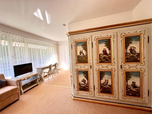 a living room with a large wall of pictures at Hotel Bergland in Grainau