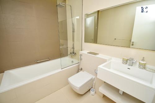 een badkamer met een wastafel, een toilet en een spiegel bij Spacious 1Bed Apt with a huge Balcony in Dubai Marina - VST in Dubai