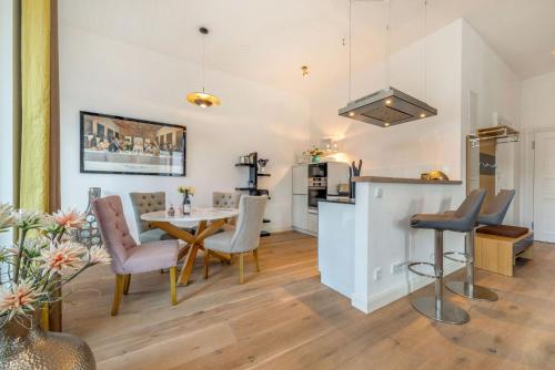 eine Küche und ein Esszimmer mit Tisch und Stühlen in der Unterkunft FIRST Avalon in Ostseebad Sellin