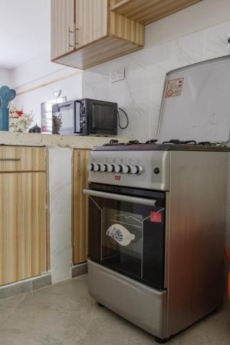 La cuisine est équipée d'un four en acier inoxydable et d'un four micro-ondes. dans l'établissement Hyrax Hill Residence, Nakuru, à Nakuru