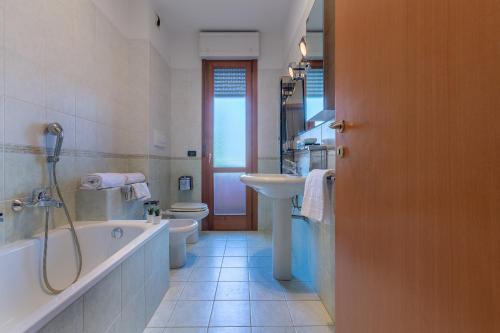 uma casa de banho com uma banheira, um lavatório e um WC. em Parco del Velodromo Comfortable Apartment em Bolonha