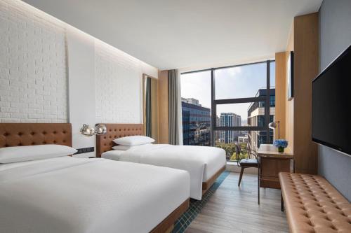 a hotel room with two beds and a large window at Four Points by Sheraton Shanghai Hongqiao in Shanghai