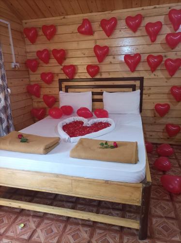 a bedroom with a bed with red hearts on the wall at Happy Shack Beach And Wooden Huts in Colva
