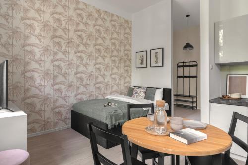 a living room with a table and a bed at HARBOR APARTMENTS - Damrota in Katowice