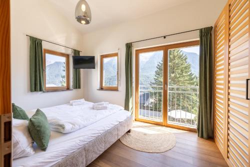 a bedroom with a large bed and a large window at Arch San Martin C in Scuol
