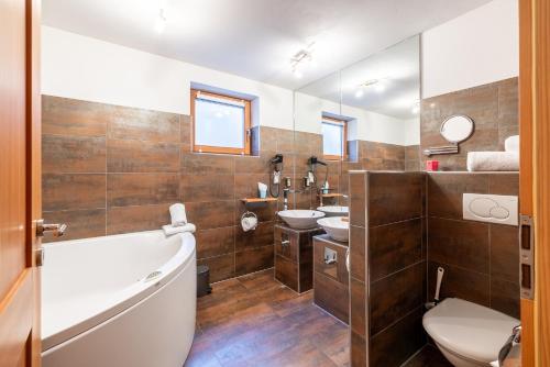 a bathroom with a tub and a toilet and a sink at Arch San Martin C in Scuol