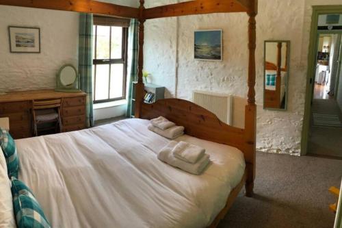 a bedroom with a large bed with two pillows on it at The Stables - Crackington Haven Cornwall in Crackington Haven