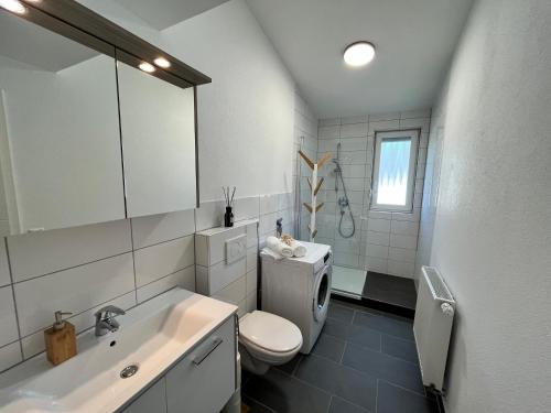 Baño blanco con aseo y lavamanos en Premium Apartment 75qm 3 Zimmer Küche, Balkon, Smart TV, WiFi, en Aalen