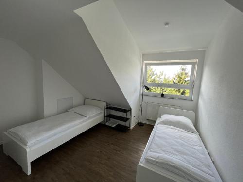 Habitación pequeña con 2 camas y ventana en Premium Apartment 75qm 3 Zimmer Küche, Balkon, Smart TV, WiFi, en Aalen