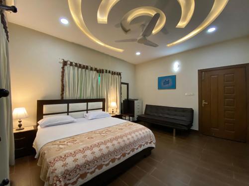 a bedroom with a bed and a ceiling fan at Alpha Guest House in Rawalpindi