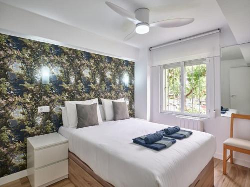 1 dormitorio con 1 cama blanca grande y papel pintado con motivos florales en NEW Plaza Elíptica Metro Bus 15 min centro 3d Luxe reformado, en Madrid