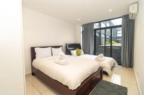 a bedroom with a large bed and a large window at Family 3 Bed Loft @Cantonments in Cantonments