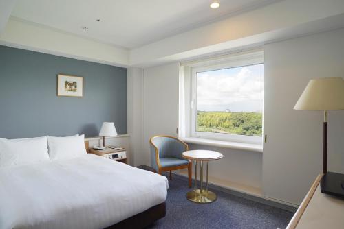 a hotel room with a bed and a window at Marroad International Hotel Narita in Narita