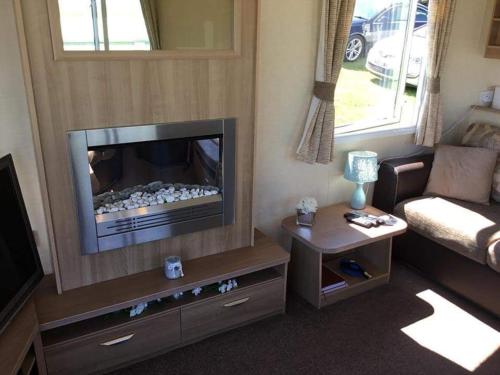 a living room with a television and a couch at Caravan - Sleeps 6 - Sea Views - Dog Friendly in Flamborough