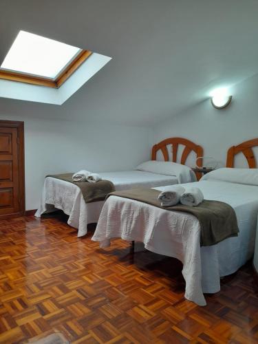 a room with two beds and a skylight at La Carlota in Llames de Pría