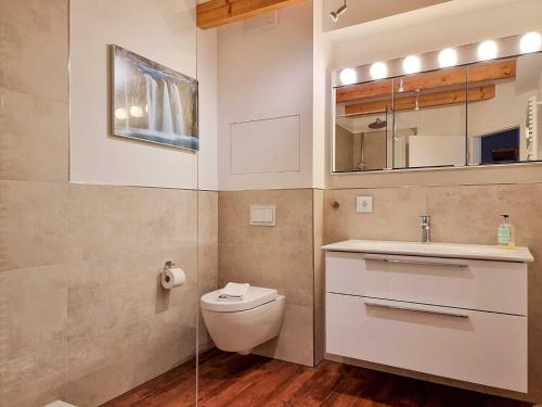 bagno con servizi igienici, lavandino e specchio di Ferienwohnung Lorenz a Sassnitz