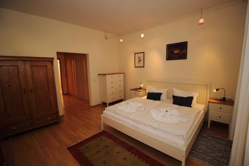 ザスニッツにあるFürstenhof - Ferienwohnung 202のウッドフロアのベッドルーム1室(白いベッド1台付)