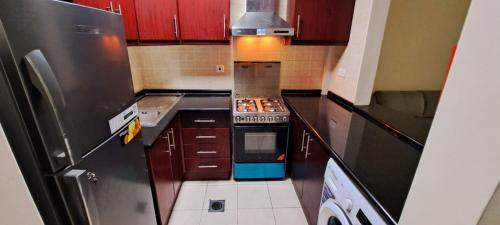 a kitchen with a refrigerator and a stove top oven at Studio flat DG079, Close to The Gardens Metro 3 min walkable in Dubai