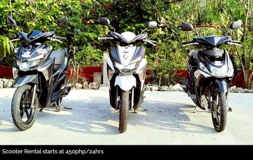 two motorcycles parked next to each other on a street at SBG Resort Lambug in Badian