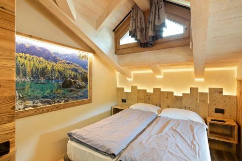 - une chambre avec un lit, une fenêtre et un tableau dans l'établissement Chalet Leur Gusja Golp Trilocale, à Livigno