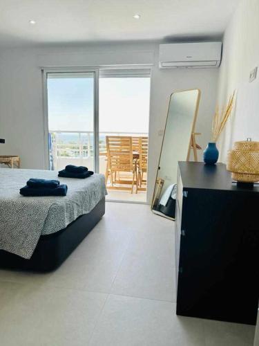 a bedroom with a bed and a table and a mirror at Perfecto Apartamento para vacaciones frente al mar in Villajoyosa