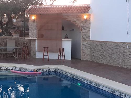 een huis met een zwembad met een tafel en stoelen bij Casa Albahacar 