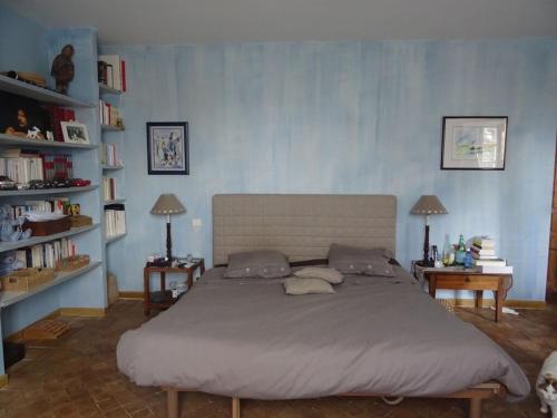 - une chambre avec un grand lit dans une chambre avec des étagères dans l'établissement Mas du Barroux, à Carpentras