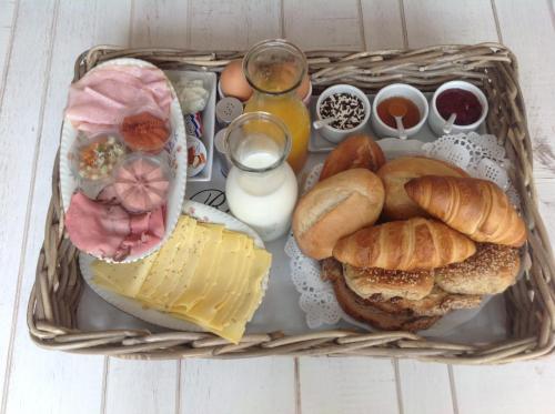 a basket filled with different types of bread and cheese at B&B De Singel in Medemblik