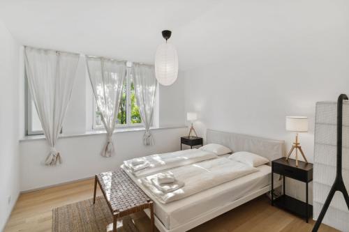 a white bedroom with a bed and a window at Zurich Flat: Central & Lake Convenience in Zürich