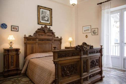 ein Schlafzimmer mit einem großen Holzbett und einem Fenster in der Unterkunft Casa Vela in Ariano Irpino