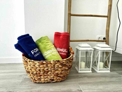 una cesta con toallas y velas junto a una silla en Anzol By FHR, en Quarteira