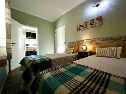 a bedroom with two beds and a window at Green House by FHR estacionamento e WI-FI in Quarteira