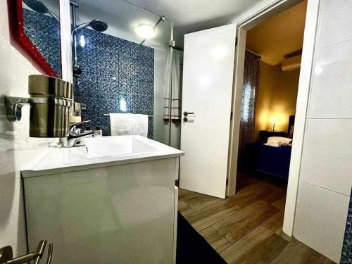 a bathroom with a sink and a room with a bed at Green House by FHR estacionamento e WI-FI in Quarteira