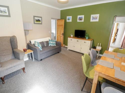 a living room with a couch and a table at Kate's Cottage in Westport