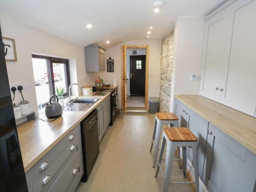 a kitchen with white cabinets and wooden counter tops at Kate's Cottage in Westport