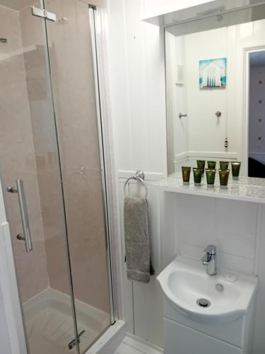 baño blanco con ducha y lavamanos en Home and Away Guesthouse, en Bridlington