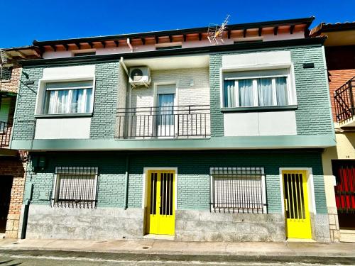 a green and white building with yellow doors at SolGredos I in Arenas de San Pedro