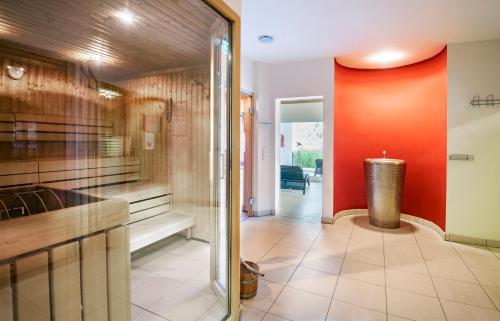 a kitchen with a red wall and a counter at Apart Hotel Legendär in Steindorf am Ossiacher See