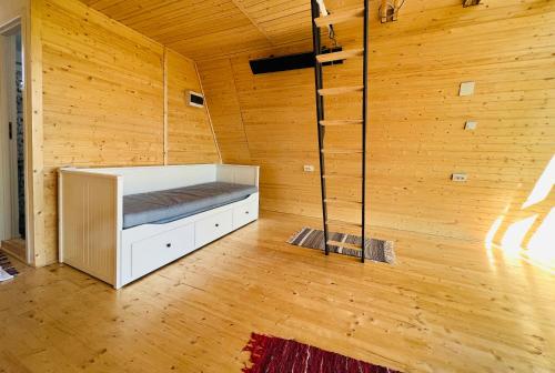 a room with a bed in a wooden wall at Horezu Cozy Cabin in Izvoru Rece