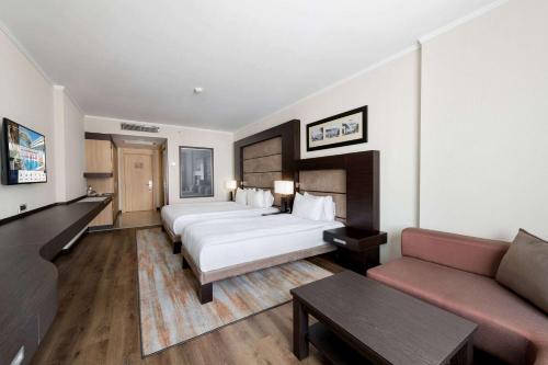 a hotel room with two beds and a couch at Ramada Plaza By Wyndham Istanbul City Center in Istanbul
