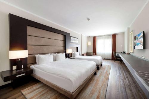 a hotel room with two beds and two lamps at Ramada Plaza By Wyndham Istanbul City Center in Istanbul