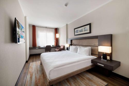 a hotel room with a large bed and a desk at Ramada Plaza By Wyndham Istanbul City Center in Istanbul