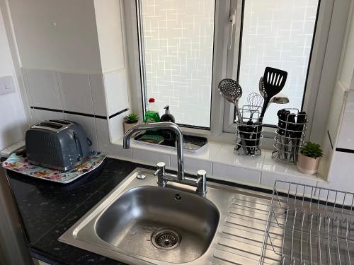 a kitchen counter with a sink and a window at TownHouse near Beach Bournemouth in Bournemouth