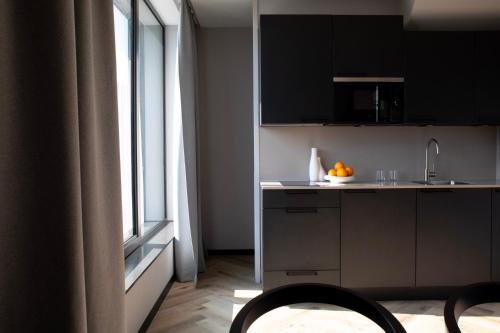 a kitchen with black cabinets and a sink and a window at Bob W Amsterdam Noord in Amsterdam