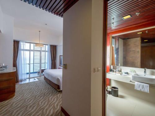 a hotel room with a bed and a bathroom at Novotel Nha Trang in Nha Trang