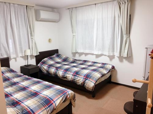 a bedroom with two beds and a window at Hotel Yuni -Comfortable stay Star-Club iD in Tokyo