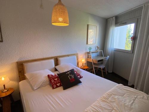 a bedroom with a white bed with two pillows on it at Appartement Montgenèvre, 2 pièces, 4 personnes - FR-1-445-172 in Montgenèvre